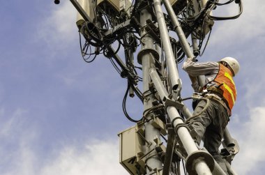 yüksek telekomünikasyon kulesinde çalışan teknisyen, işçi yüksek riskli iş için Kişisel Koruma Ekipmanları giymek, yüksek kule üzerinde inceleme ve bakım ekipmanları.