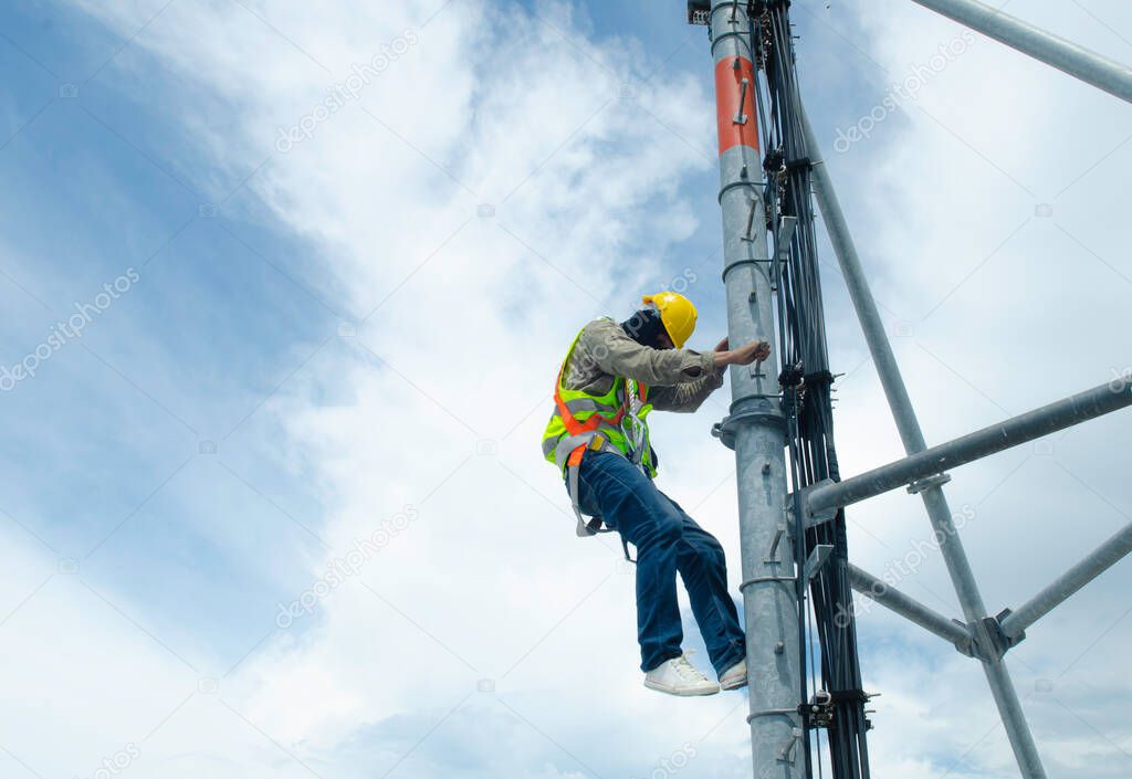 Engineer wear safety equipment and climbing high telecommunication tower for maintenance working