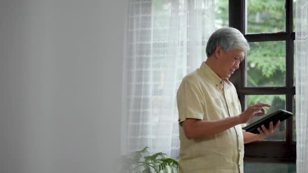 Portret Asian Starszy Człowiek Przy Pomocy Tabletka Badawczy Online Zakupy — Wideo stockowe
