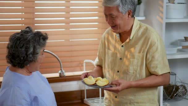 Asiático Casal Sênior Comer Maçã Fruta Cozinha Casa — Vídeo de Stock