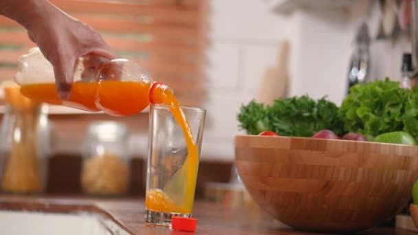 Nahaufnahme Senior Hand Gießt Orangensaft Ins Glas Und Trinken Der — Stockvideo