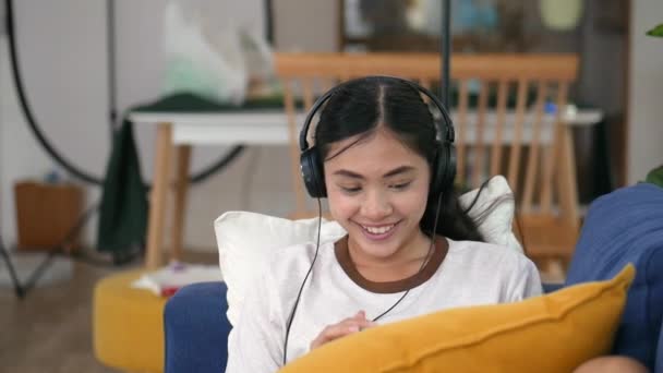 Portrét Nádherné Mladé Asijské Ženy Pohovce Sluchátky Obývacím Pokoji — Stock video