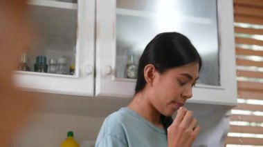 Tablet kullanan ve ekmek yiyen asyalı genç bir kadın. evde mutfakta teknoloji, sosyal ağ, iletişim konsepti.