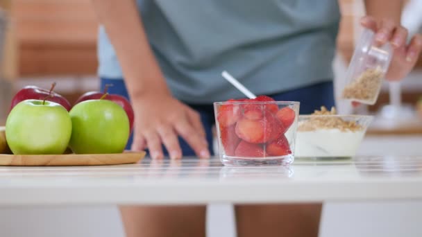 イチゴのスムージーを作るためのアジアの女性の食材をクローズアップ自宅のキッチンで健康的な朝食を調理します 高角ショット — ストック動画