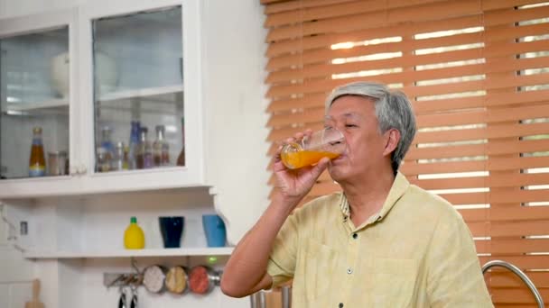 Portrait Senior Asiatique Homme Boire Jus Orange Dans Cuisine Maison — Video