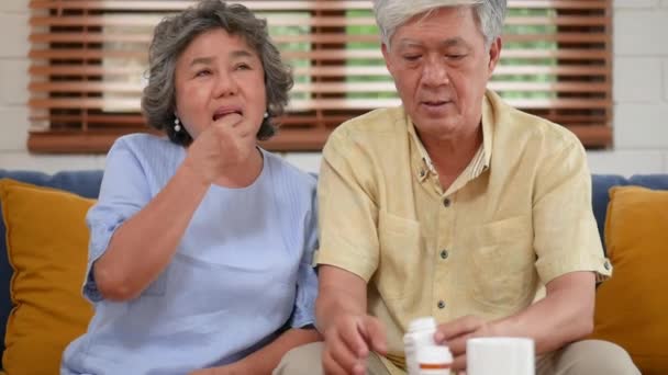 亚洲老年夫妇老人吃药 在家里的客厅里喝水 — 图库视频影像