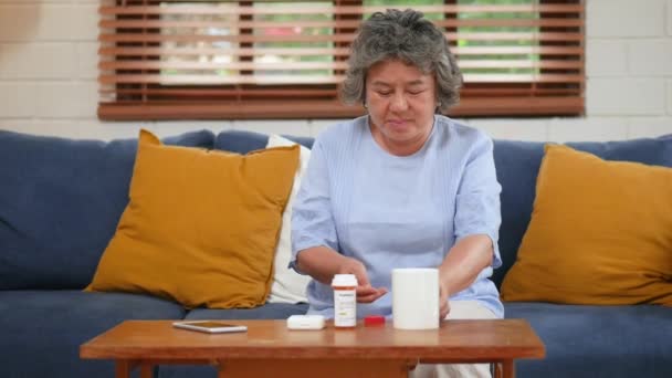 Asiatische Seniorin Nimmt Tabletten Trinkt Wasser Heimischen Wohnzimmer — Stockvideo
