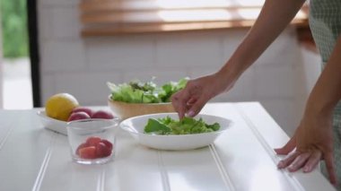 Evde mutfakta sağlıklı bir kahvaltı pişirme salata, sebze, çilek yapmak için Asyalı kadın malzemeler kapatın.