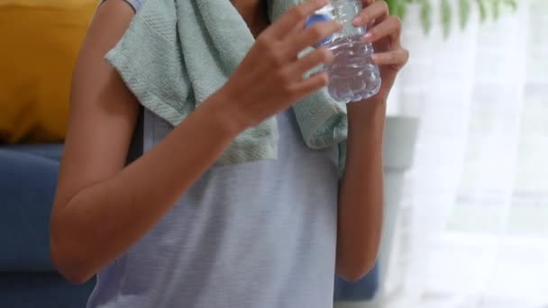 年轻的亚洲妇女在家里的客厅里锻炼 饮用水 — 图库视频影像