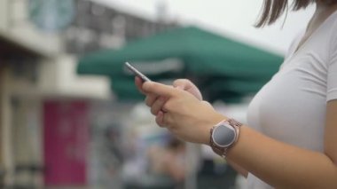 Asyalı kadın akıllı telefon kullanarak açık park. Yavaş çekim yakın. arama internet, online teknoloji.