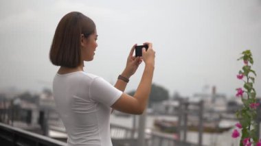 Akıllı telefon kullanan genç Asyalı kadın fotoğraf çekmek. Tayland Güzel Asyalı kız turist seyahat.
