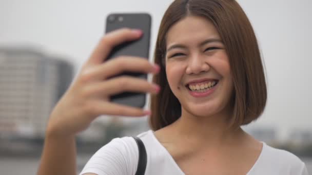 Hermosa Mujer Asiática Joven Que Tiene Chat Vídeo Utilizando Teléfonos — Vídeos de Stock