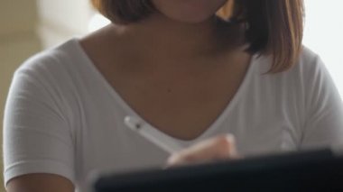 Genç Asyalı kadın yaratıcı tasarımcı onun projesi için planlama kahve dükkanında bir tablet kullanarak. arama internet, online teknoloji.