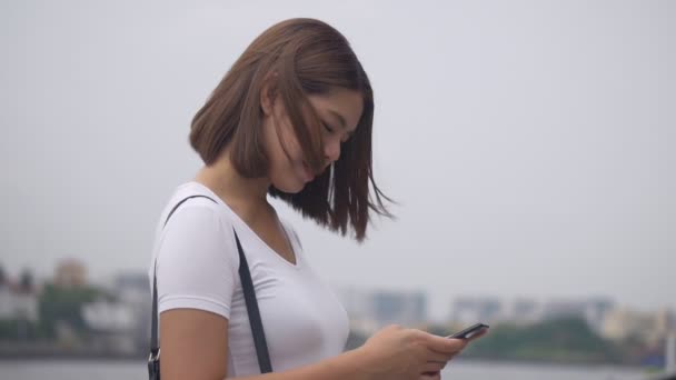 Mulher Asiática Nova Bonita Usando Smartphone Que Gosta Ler Mídias — Vídeo de Stock