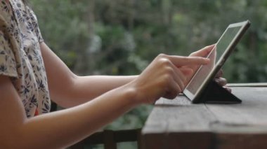Kafede tablet kullanan asyalı genç bir kadın. Teknoloji sosyal medya.