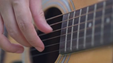 Halka açık bir parkta gitar çalan kız elinin yavaş çekim yakınçekimi.