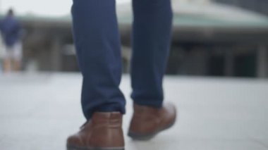 Sokakta yürüyen Asyalı işadamının bacaklarını kapatın.