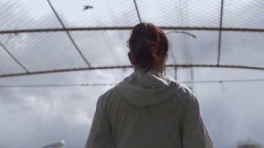 Güzel genç Asya fitness koşucusu sporcu bir şehir şehir etrafında bakıyor. Yağmurdan önce kara bulut.