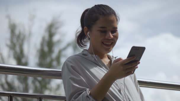 Улыбающийся Портрет Красивая Молодая Азиатка Фитнес Бегунья Стоящая Мобильного Телефона — стоковое видео