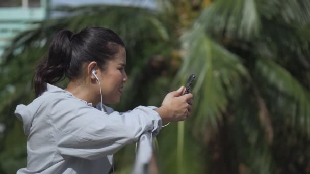 Улыбающийся Портрет Красивая Молодая Азиатка Фитнес Бегунья Стоящая Мобильного Телефона — стоковое видео