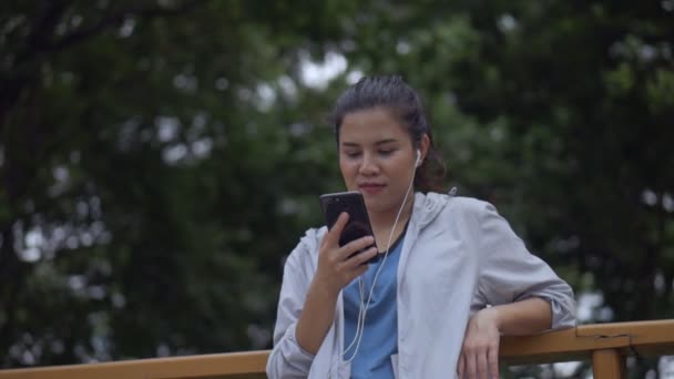 Улыбающийся Портрет Красивая Молодая Азиатка Фитнес Бегун Помощью Мобильного Телефона — стоковое видео