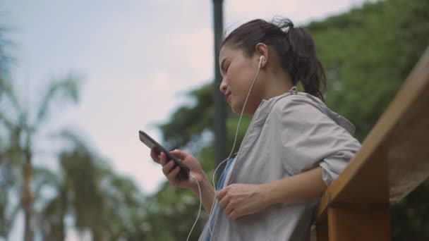 Портрет Красивая Молодая Азиатка Фитнес Бегун Помощью Мобильного Телефона Слушать — стоковое видео