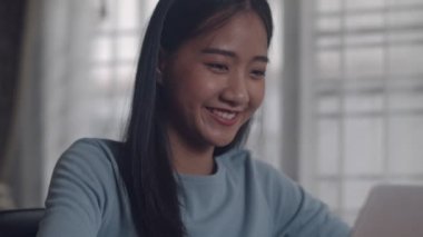 Güzel gülümseyen portre Asyalı kadın yaratıcı tasarım bir dizüstü bilgisayar kullanarak-ev ofis. İş Kadını evde çalışan çekici freelancer.