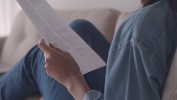 Fechar Mãos Mulher Asiática Segurando Lendo Documentos Enquanto Senta Sofá — Vídeo de Stock