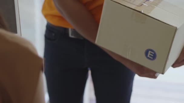 アジアの若い女性がタブレットに署名を入れている間 段ボール箱を持っている若い配達アジアの男性 — ストック動画