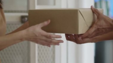 Yavaş Hareket: Yakın eller Asyalı kadın evde tutan bir adamın teslimat bir karton kutu almak.