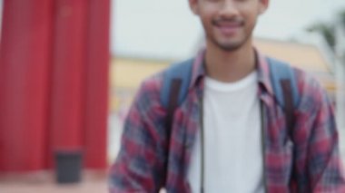 Dolly, Tayland 'ın dev salıncağının fotoğrafını çeken yakışıklı Asyalı genç turistlerin gülümseyen portresini yakınlaştır. Asyalı blogcu mutlu mesut seyahat ediyor..