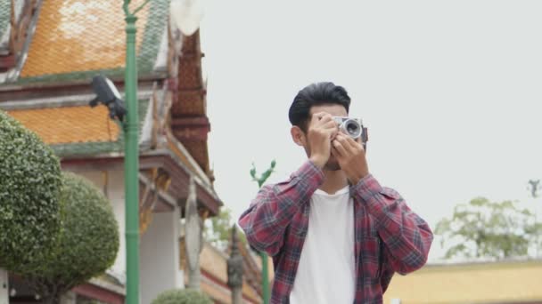 魅力的な若いアジアの男の観光客が旅行し 寺院タイで写真を撮る アジアの男性ブロガー幸せなレジャーライフスタイル旅行を楽しむ — ストック動画