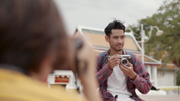 Turisté Asijské Muž Pomocí Filmové Kamery Fotografování Zatímco Sedí Ulici — Stock video