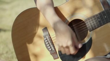 Kapatın ellerinizi Asyalı kadın gitar çalıyor arkadaşlarıyla kamp yapıyor eğleniyor ve bira içiyor..