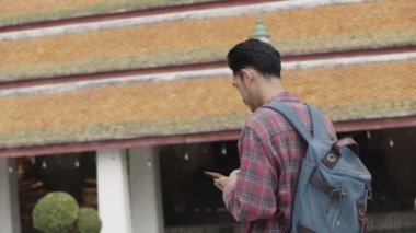 Tek başına gezen Asyalı turistler Tayland tapınağında arkadaşlarıyla gezip sohbet ediyorlar. Asyalı blogcu mutlu mesut seyahat ediyor..