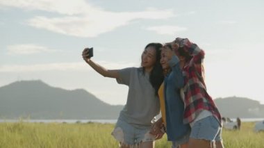 Genç bir Asyalı kadın grubu selfie çekiyor yaz tatilinde birlikte eğleniyorlar. Yaşam tarzı tatil tatili. Bir dağ geçmişine sahip olmak.