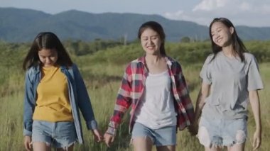 Bir grup genç Asyalı kadın el ele tutuşup yaz tatilinde eğleniyorlar. Yaşam tarzı tatil tatili. Bir dağ geçmişine sahip olmak.