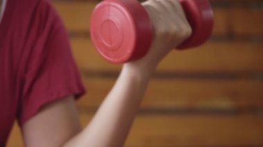 Spor salonunda halterle egzersiz yapan Asyalı sporcu kadın..