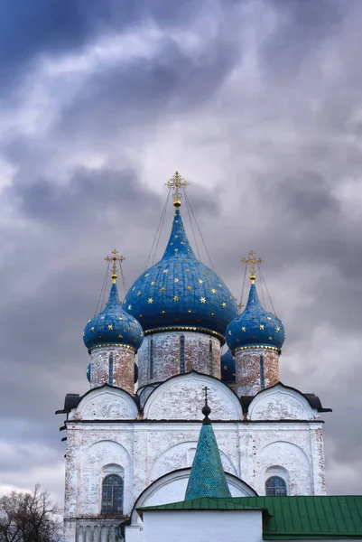 the blue with gold stars domes of the Orthodox Church on the bakground of stormy purple sky, Suzdal Kremlin Russia