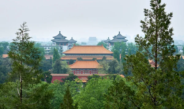 View of Beijing from the hill of Jingshan Park. At the northern foot of the hill is the Hall of Imperial Longevity. Cityscape in the smog. The tablet translation \