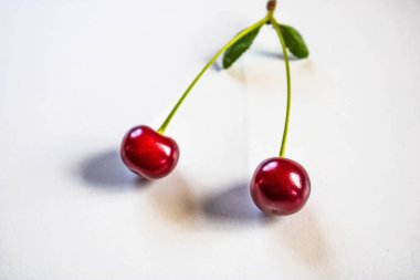 Ağaçta kırmızı kiraz. Olgun kirazlar sap ve yapraklarla hasat sonrası sepette.