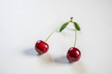 Ağaçta kırmızı kiraz. Olgun kirazlar sap ve yapraklarla hasat sonrası sepette.