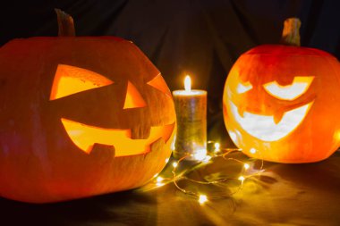 Siyah arka planda mumları olan Cadılar Bayramı balkabakları