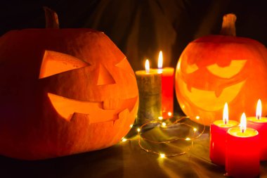 Siyah arka planda mumları olan Cadılar Bayramı balkabakları