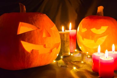 Siyah arka planda mumları olan Cadılar Bayramı balkabakları