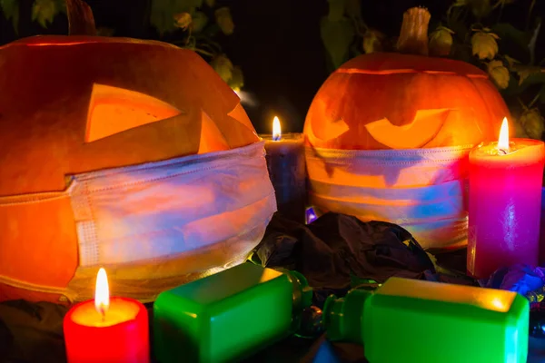 橙色南瓜戴着一个保护的医疗面具 秋天的第二波珊瑚病毒感染 万圣节的概念和Covid 万圣节南瓜 带有黑色背景的蜡烛 — 图库照片