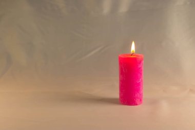 Arkaplanı yanan küçük bir alevi olan ince bir mum. Mumlar eski bir masada. Güzel koyu arkaplan. Dini kavram.