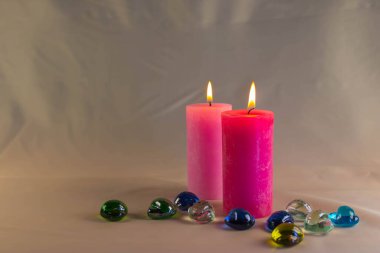 Arkaplanı yanan küçük bir alevi olan ince bir mum. Mumlar eski bir masada. Güzel koyu arkaplan. Dini kavram.