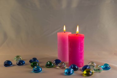 Arkaplanı yanan küçük bir alevi olan ince bir mum. Mumlar eski bir masada. Güzel koyu arkaplan. Dini kavram.