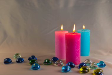 Arkaplanı yanan küçük bir alevi olan ince bir mum. Mumlar eski bir masada. Güzel koyu arkaplan. Dini kavram.